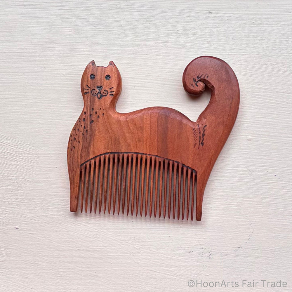 tiny cat comb made out of apricot wood with detailed carving handcarved and fairtrade
