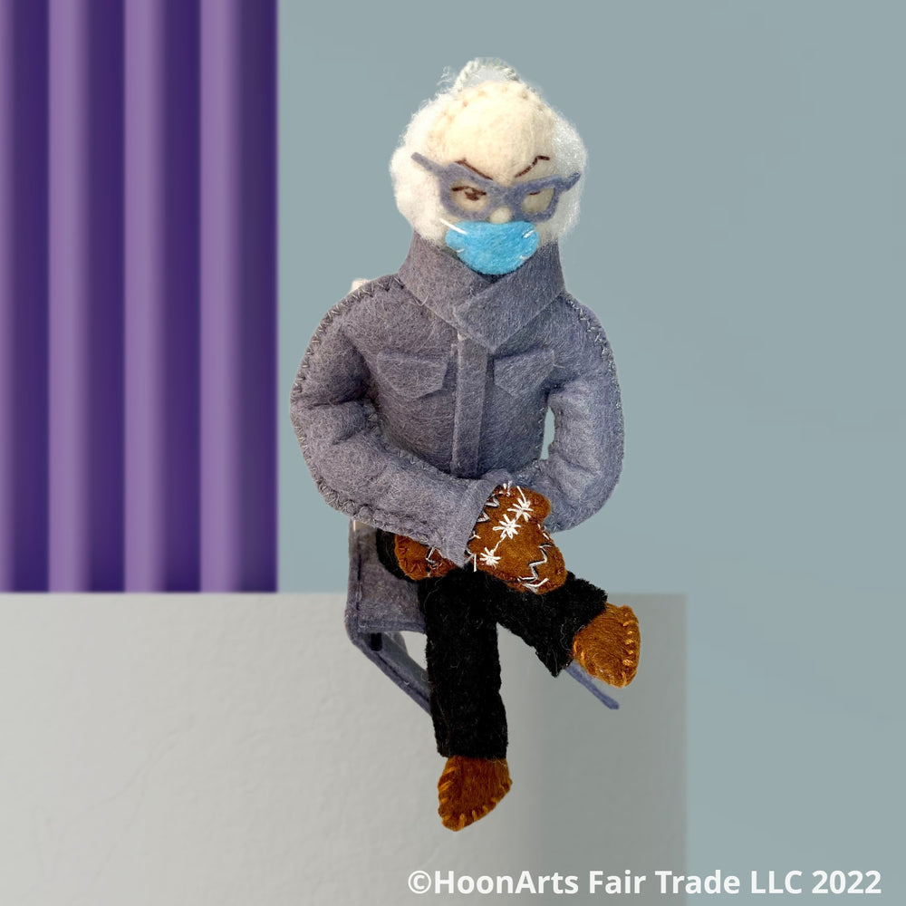 Bernie Sanders on Inauguration Day sitting on a plain podium with purple wall background