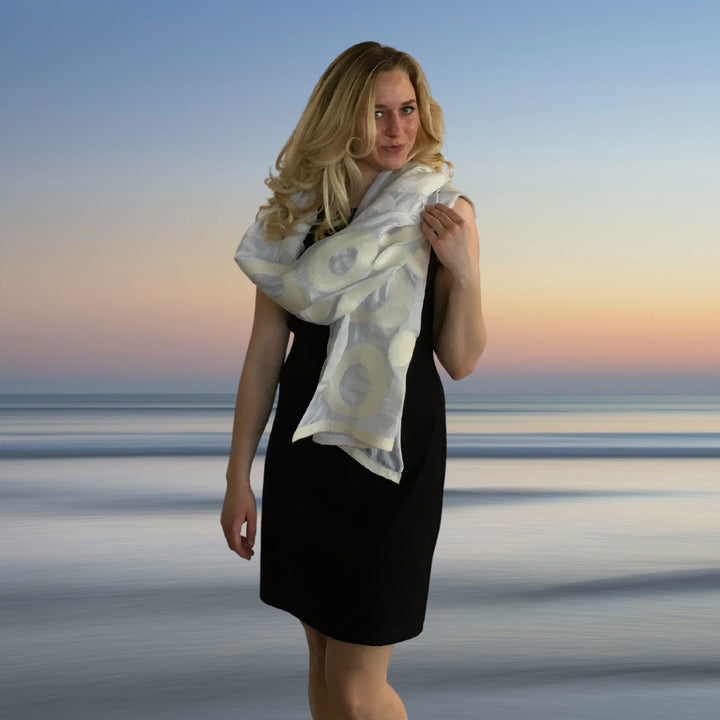 Model wearing white felted silk wrap with sunset in background