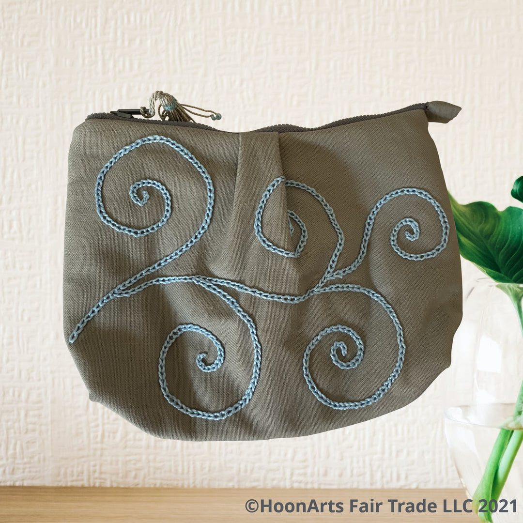 hand embroidered blue swirl pattern on grey clutch bag