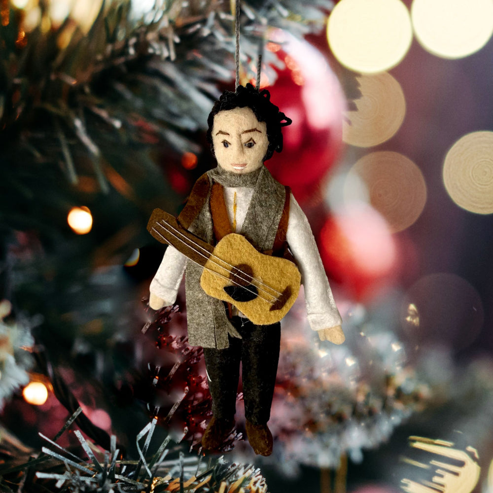 Bob Dylan with guitar-felt Christmas ornament hanging from Christmas tree