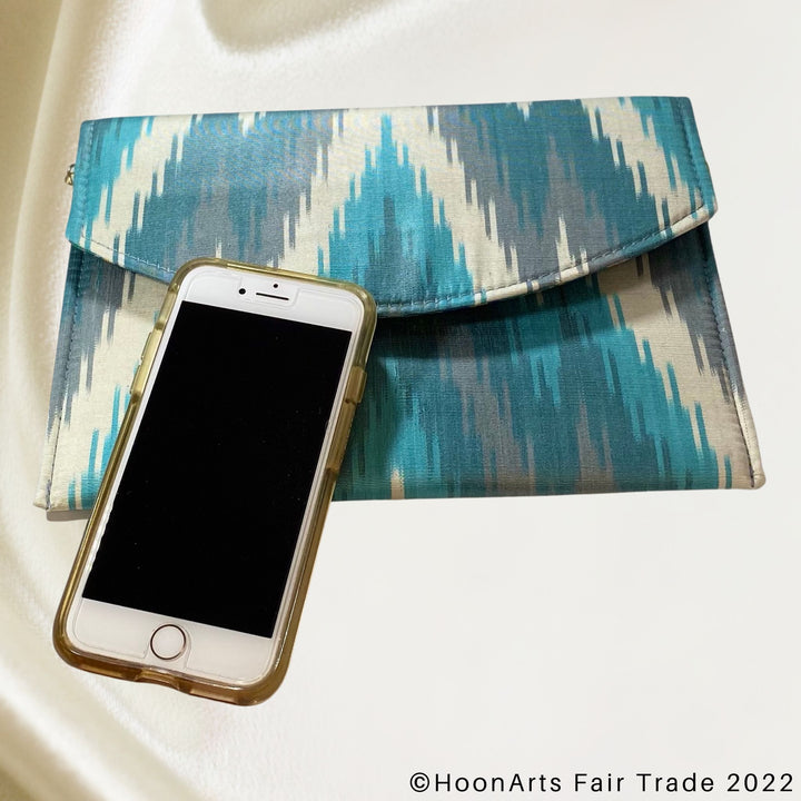 Turquoise & Grey Arrow Ikat Clutch scale with phone